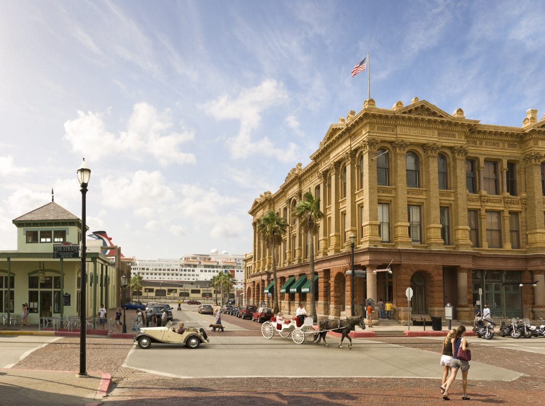 Street view with old fashioned car and a horse pulled carriage in Galveston, Texas