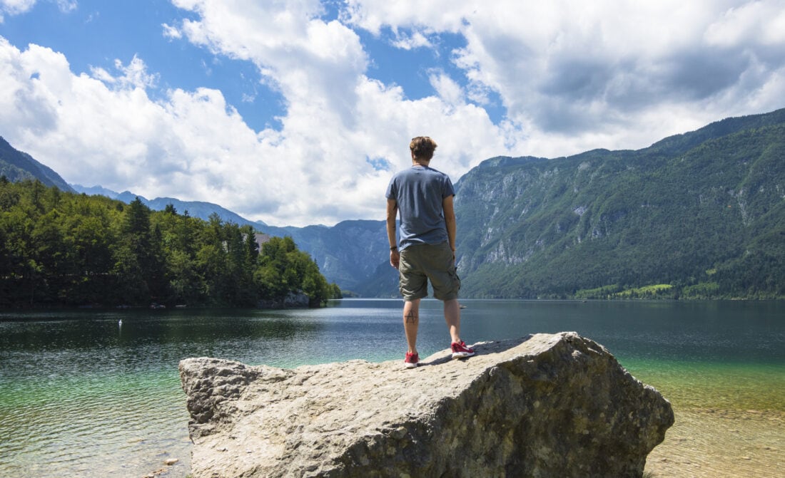 man standing on a rock over looking a lake in Slovenia