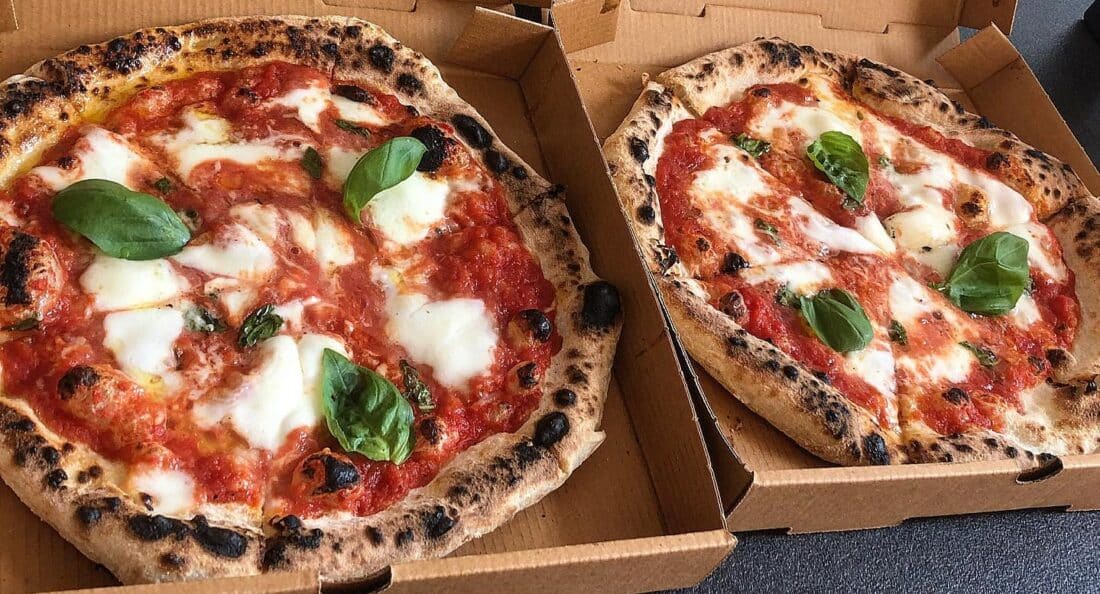 two pizzas side by side