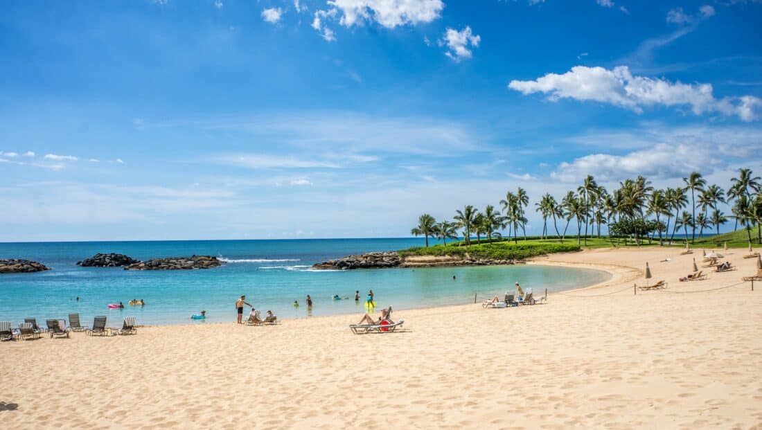 People on beach chairs near the water on Ko Olina beach in Hawaii