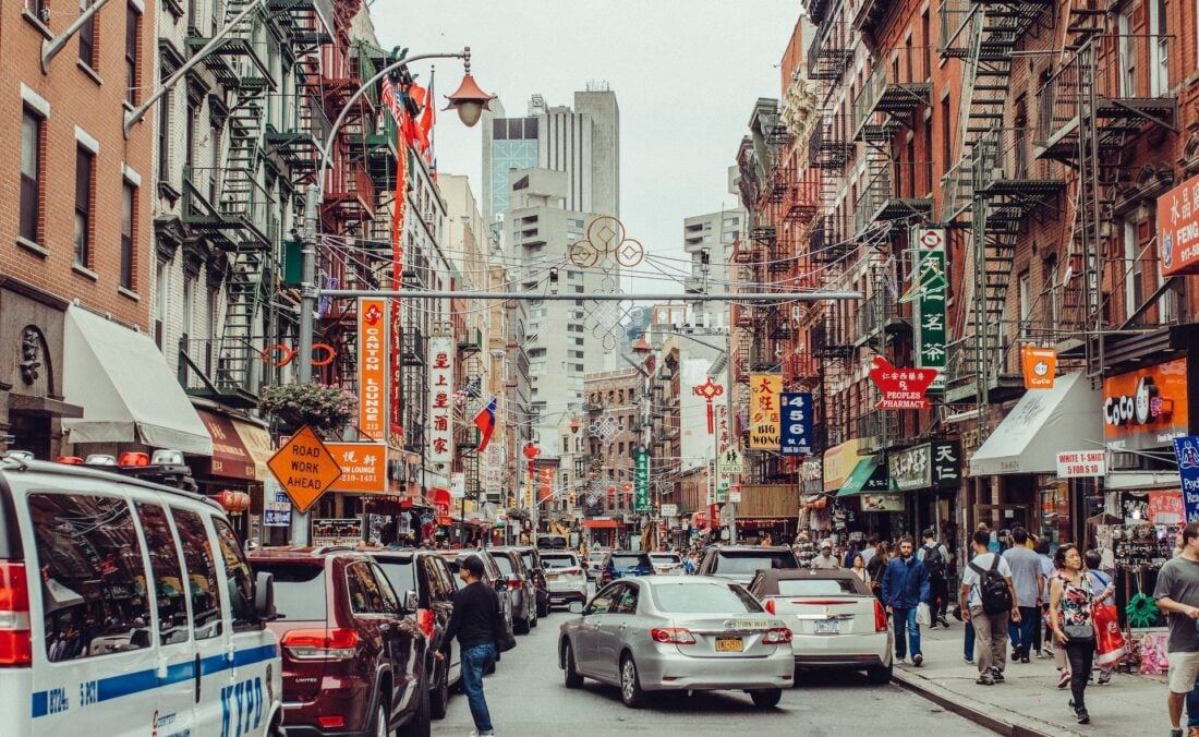 People and cars on a crowded street in Chinatown New York