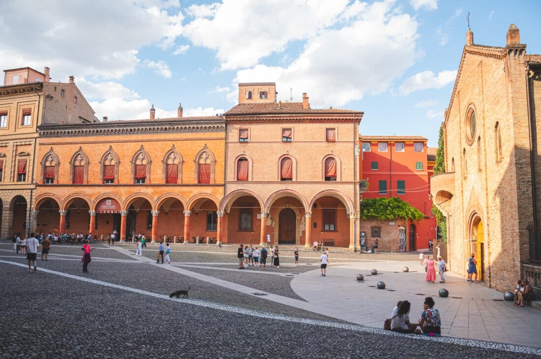 People sitting in front of a church during golden hour in piazza santo stefano in bologna italy 