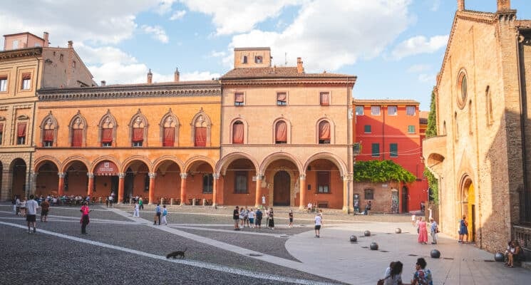 People sitting in front of a church during golden hour in piazza santo stefano in bologna italy