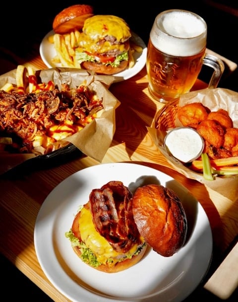 Burgers, fries, and cauliflower wings with a beer at BarFood, the best sports bar Prague alternative.