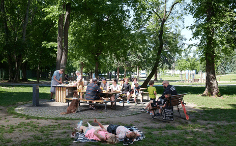 The grilling area at Stromovka with people grilling and sitting on benches, the best Prague alternative to a backyard bbq. 